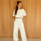 model wearing off white cropped short sleeve top and matching wide leg pants