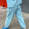 back view of model wearing sky blue cotton balloon pants and matching t-shirt