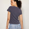 back view of model wearing vintage black relaxed baby tee with charlie brown graphic 'relax & take care' typography