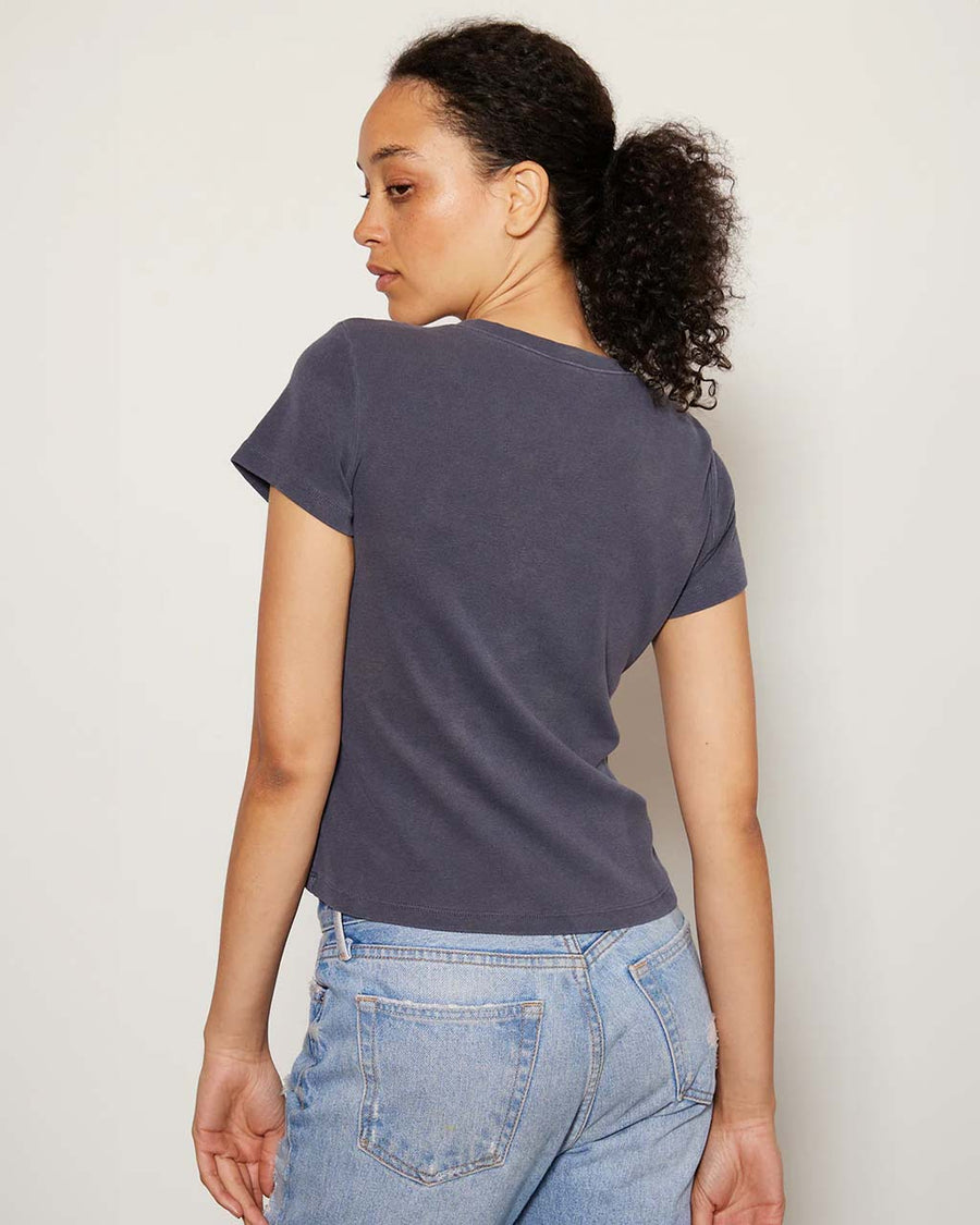 back view of model wearing vintage black relaxed baby tee with charlie brown graphic 'relax & take care' typography