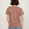 back view of model wearing brown relaxed tee with snoopy graphic 'slow down and take care' typography