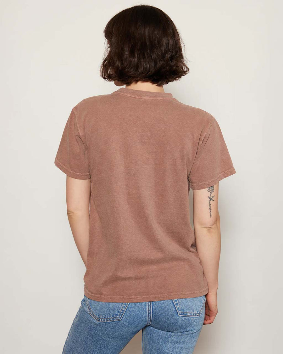 back view of model wearing brown relaxed tee with snoopy graphic 'slow down and take care' typography