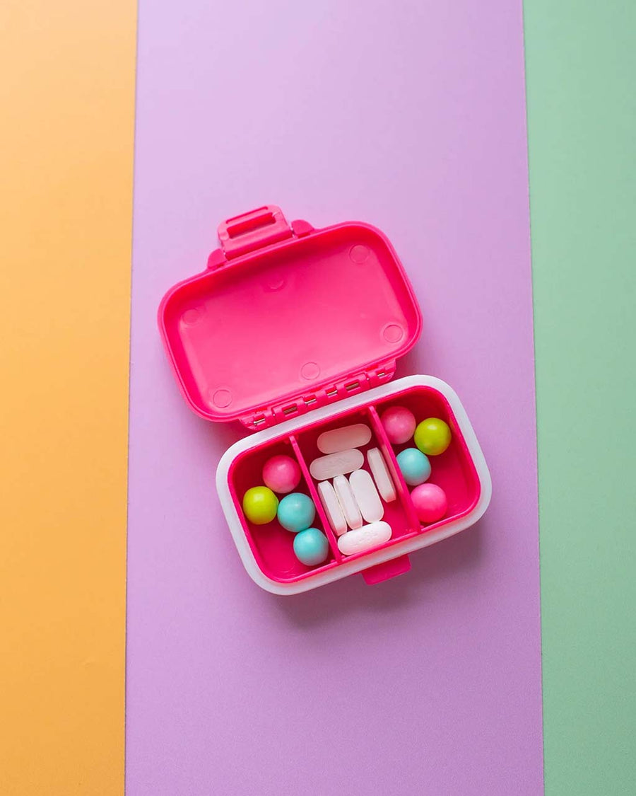 opened hot pink pill case with yellow 'attention deficit girlie across the front