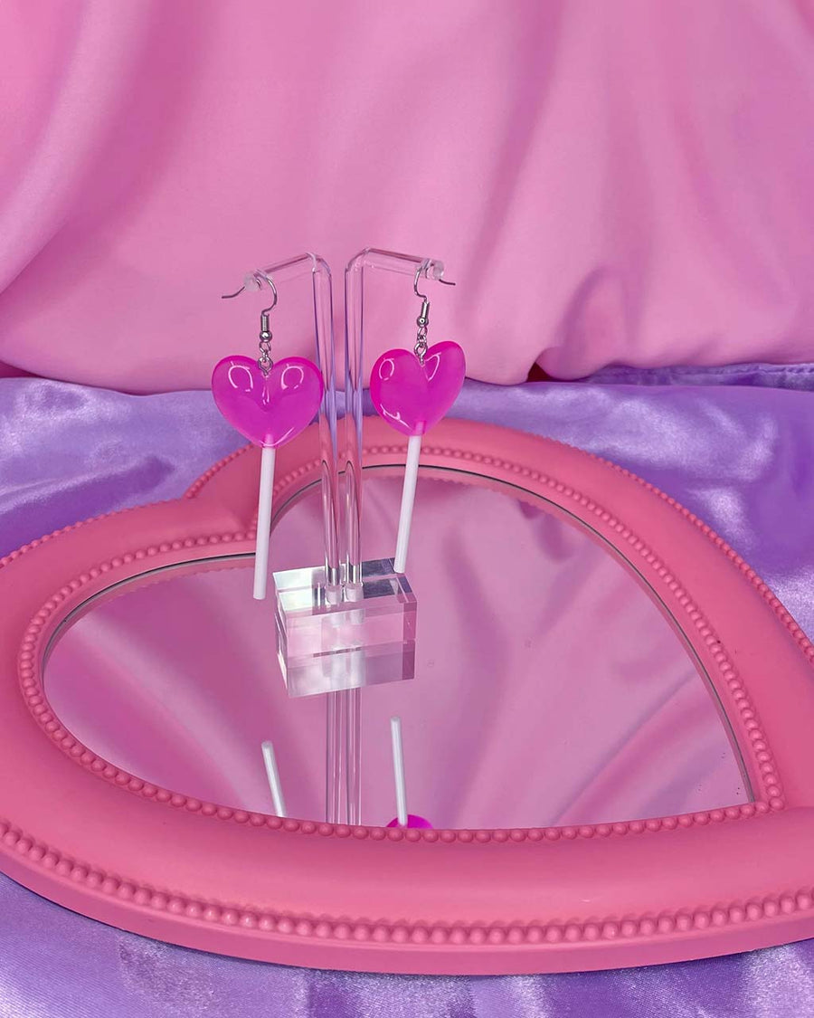 pink heart lolli dangle earrings on a display