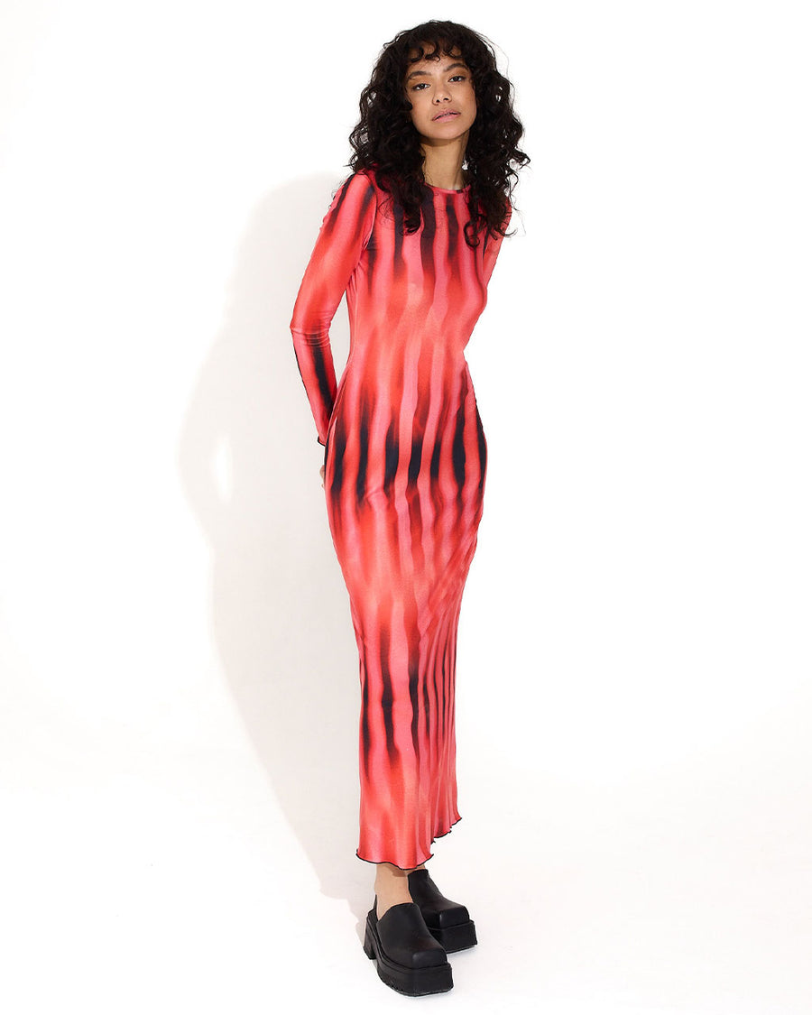 model wearing pink, red and black midi dress with long sleeve and lettuce hem