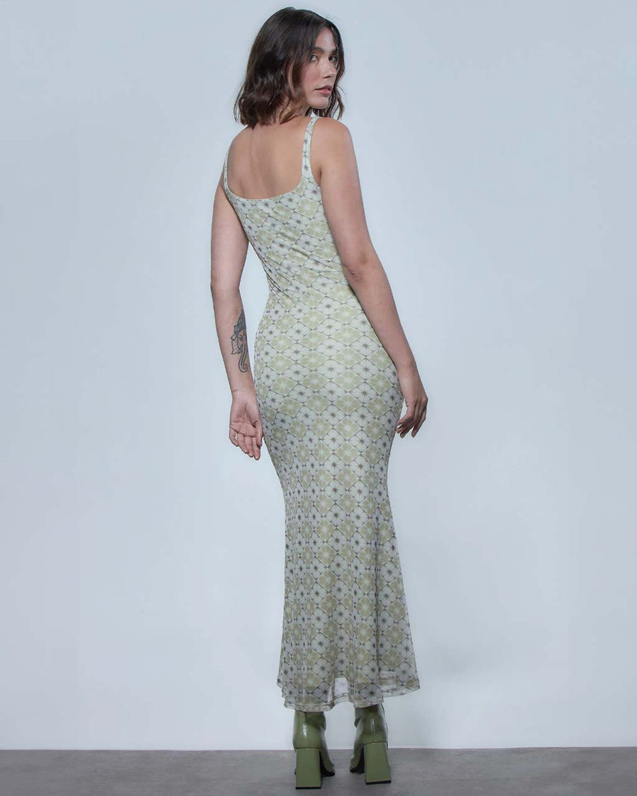 back view of model wearing skin tight tank midi dress with green and white floral tile print
