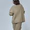 back view of model wearing biscuit double zipper sweater with relaxed fit, ribbed material and oversized patch pockets