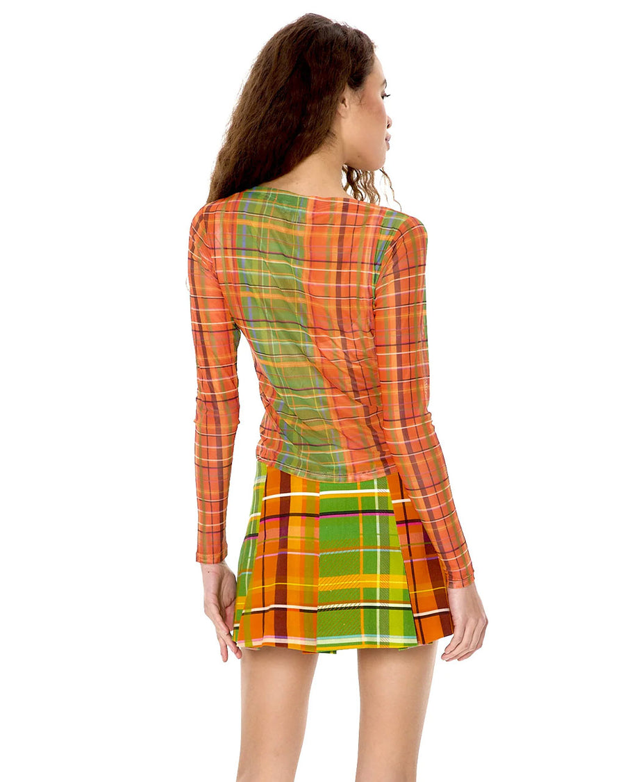 back view of model wearing orange, blue and green plaid sheer top with boat neckline and long sleeves