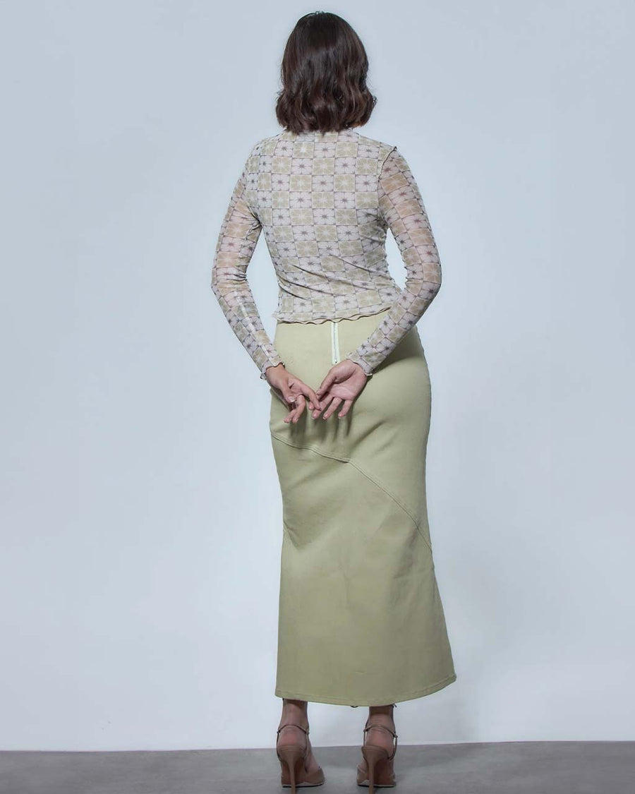 back view of model wearing tight long sleeve top with green and white flower tile print