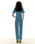 back view of model wearing denim jumpsuit with geo pattern and zip front