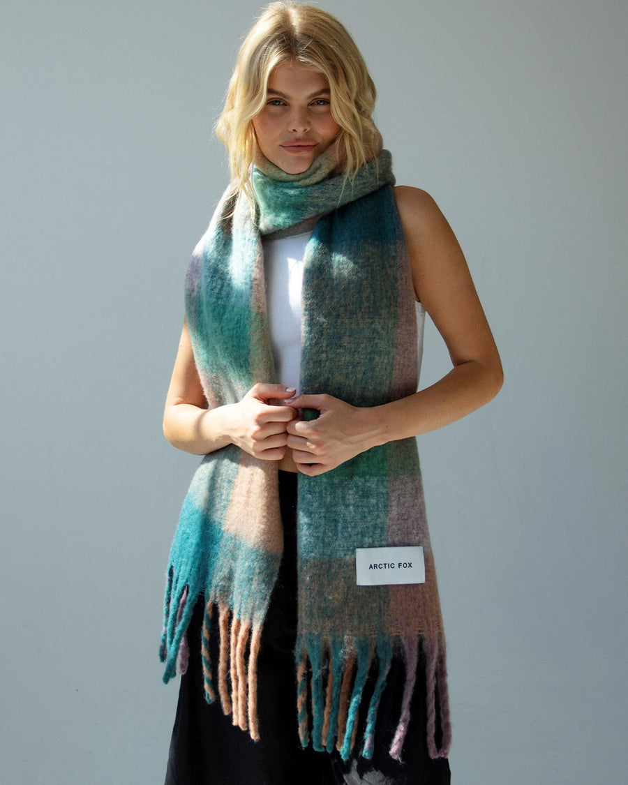 model wearing teal, salmon, green and lilac oversized checker scarf with fringe