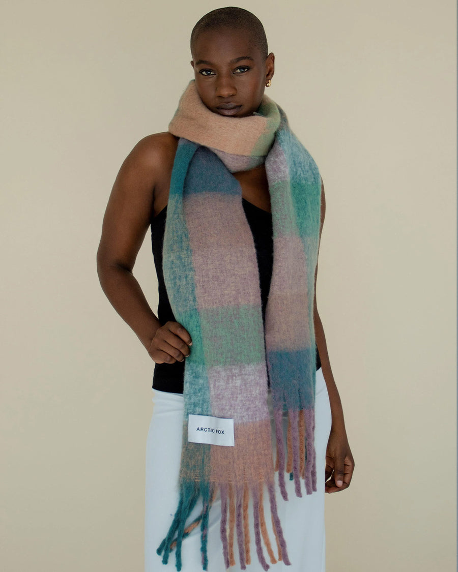 model wearing teal, salmon, green and lilac oversized checker scarf with fringe