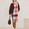 model wearing thick scarf with various shades of blue  and red checkers and fringe