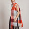 side view of model wearing thick scarf with various shades of blue  and red checkers and fringe
