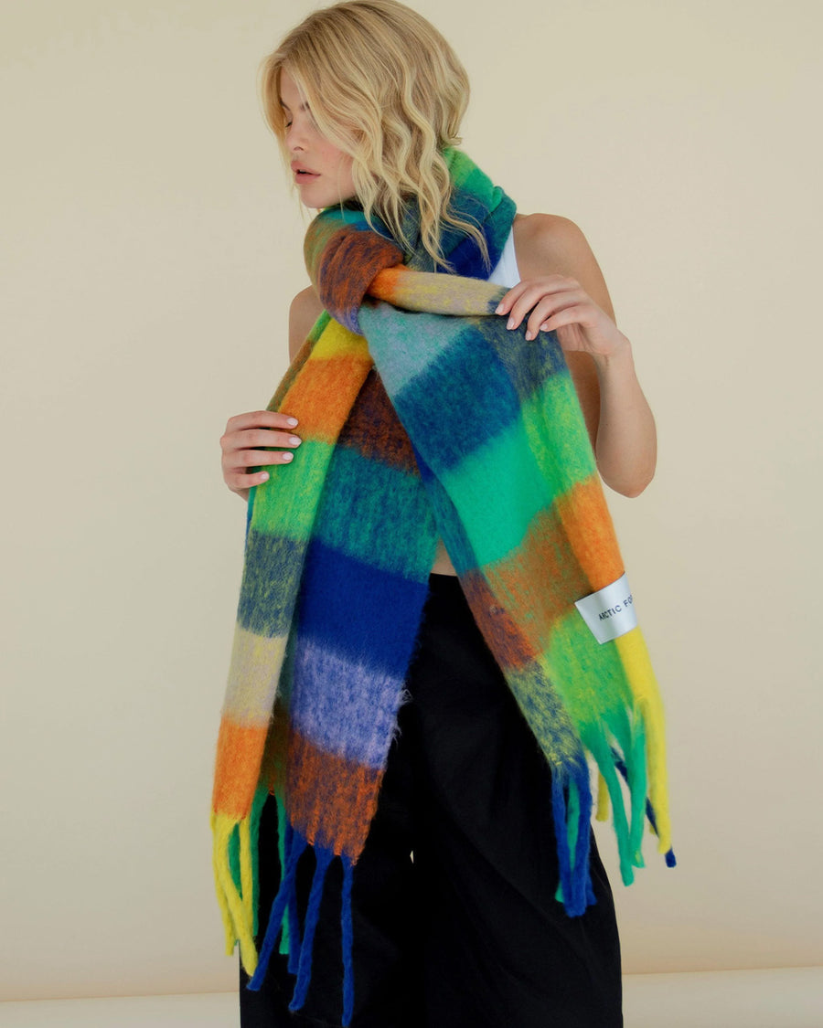 model wearing multicolored oversized checkered scarf with fringe