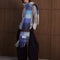 model wearing thick scarf with various shades of blue checkers and fringe