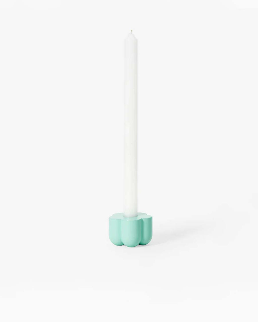 blue flower shaped holder with a taper candle in it