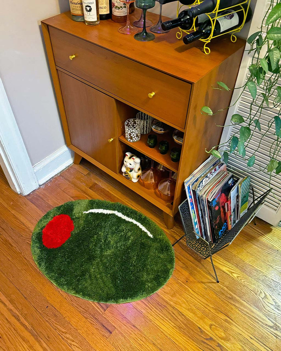 green olive shaped rug near bar cart