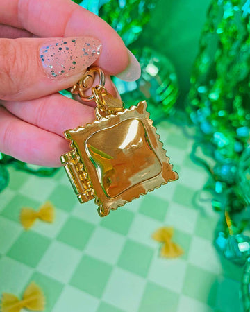model holding gold ravioli locket keychain