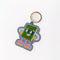 side view of enamel keychain with green book man with arms, face and legs