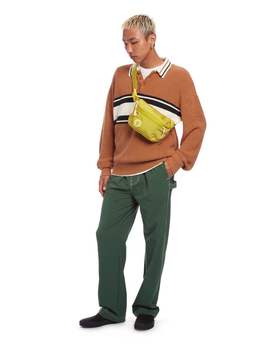 model wearing avocado green fanny pack with multiple pockets