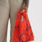 model holding red baby baggu with purple snapdragon print
