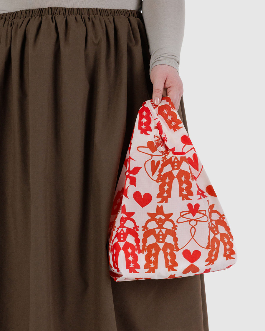 model holding cream baby baggu with red cowgirl print