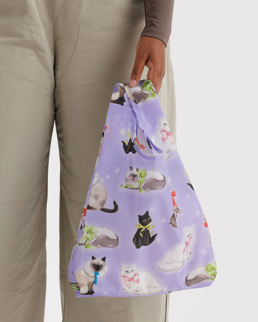 model holding purple baby baggu with various cats with ribbons tied around their necks