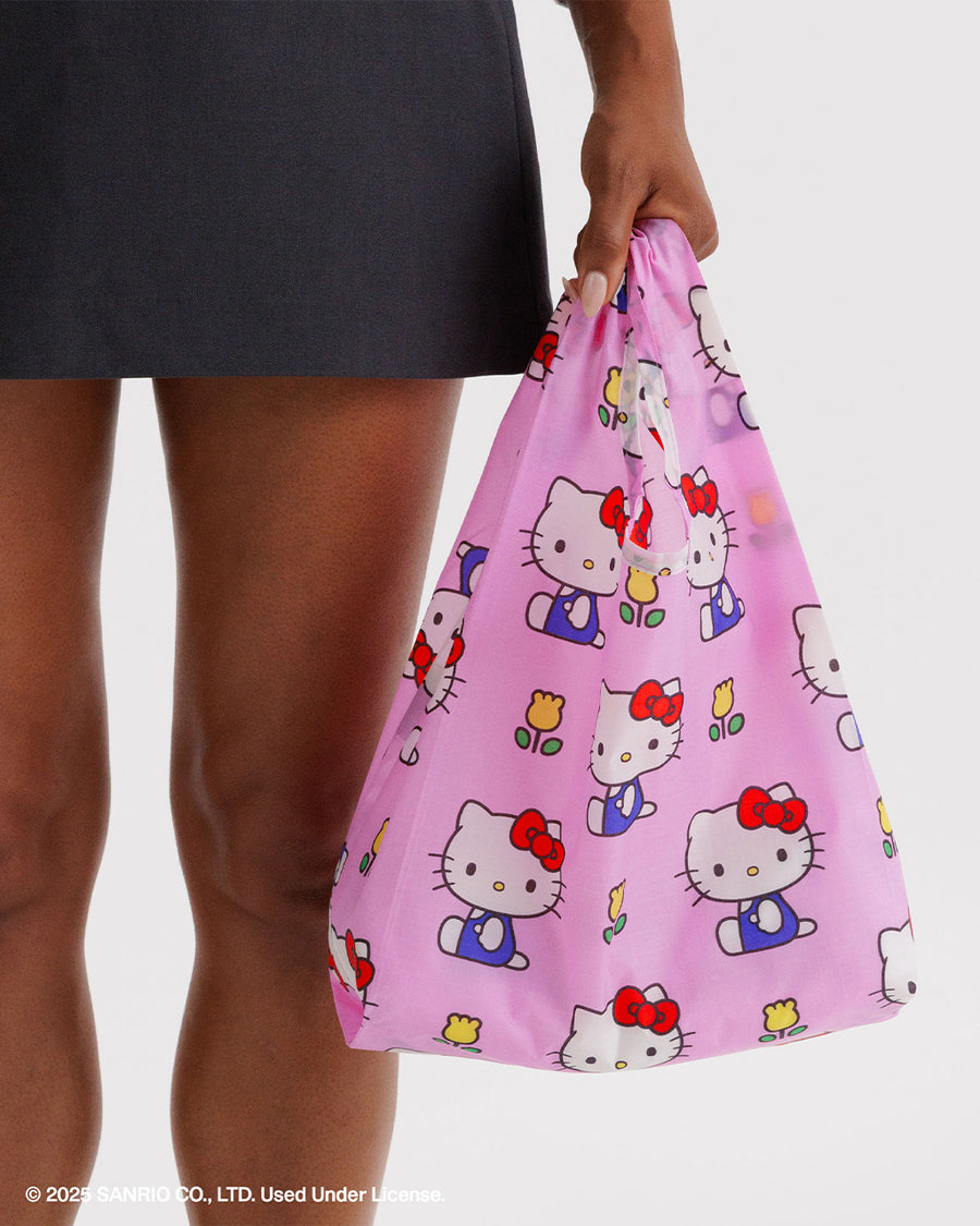 model carrying pink baby baggu with hello kitty and yellow tulips