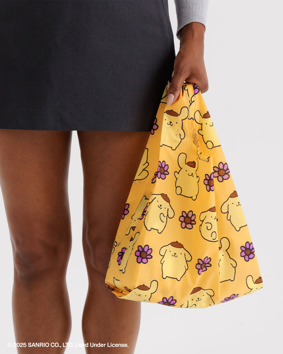 model carrying yellow baby baggu with pompompurin and pink flowers