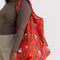 model carrying coral big baggu with western hello kitty print, horse, cactus, and star print