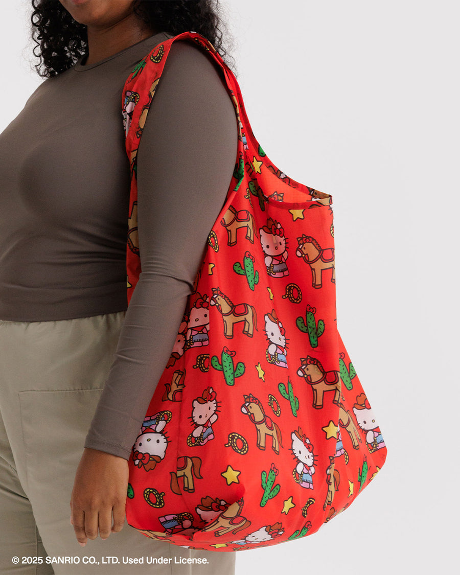 model carrying coral big baggu with western hello kitty print, horse, cactus, and star print