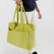model holding lime green baggu cloud carry-on bag