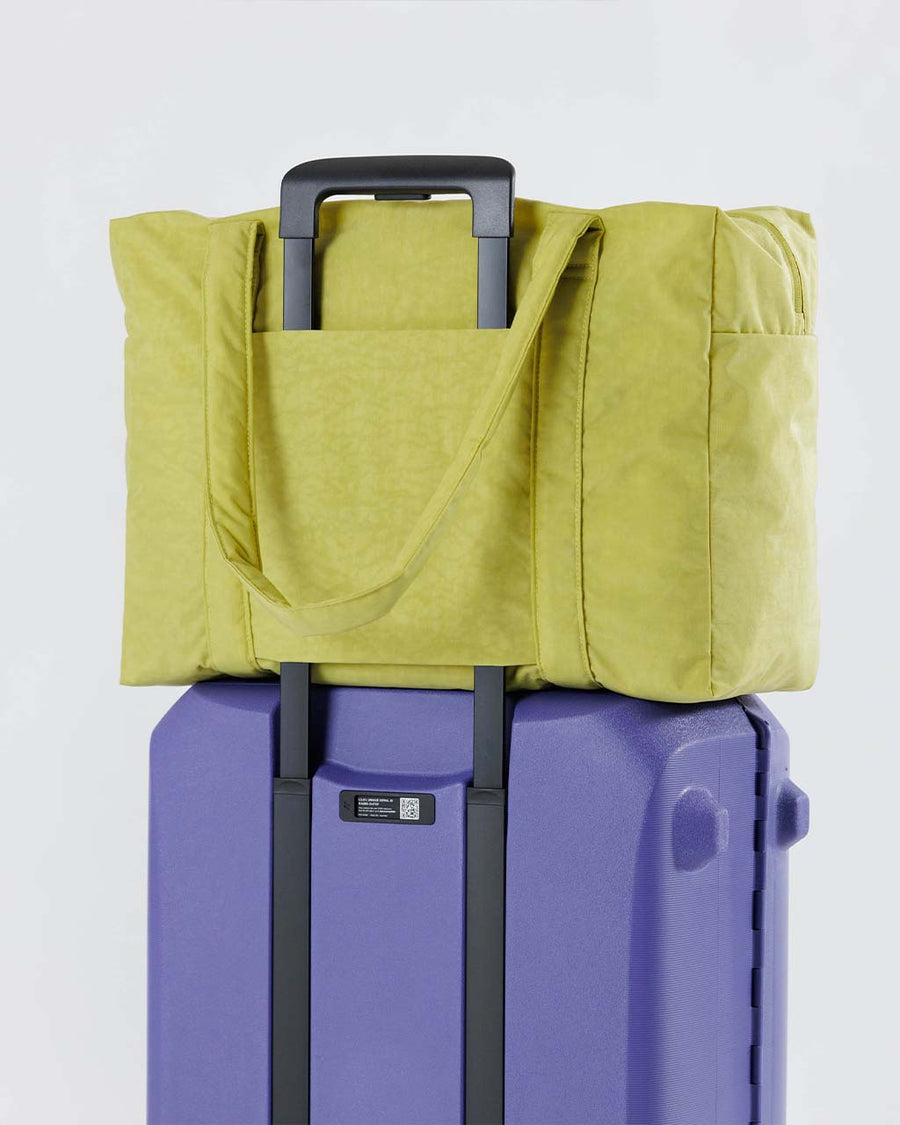 lime green baggu cloud carry-on bag on suitcase