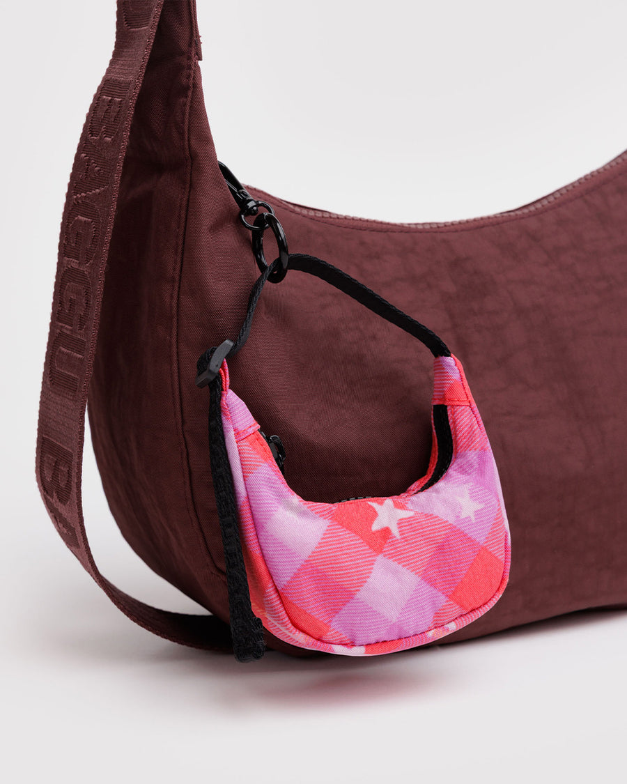 pink starry plaid crescent bag charm on a maroon bag