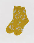 mustard yellow baggu socks with ice blue smiley faces