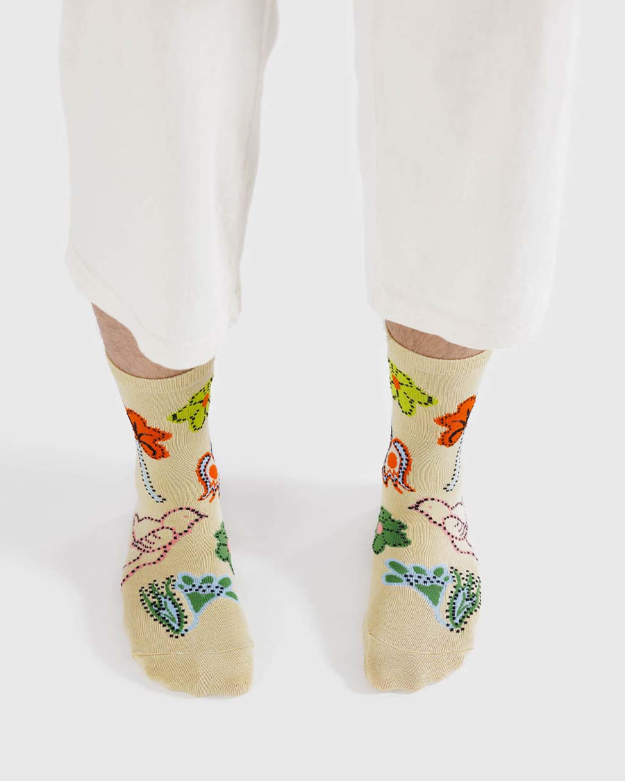 model wearing pale yellow socks with colorful floral and bird print