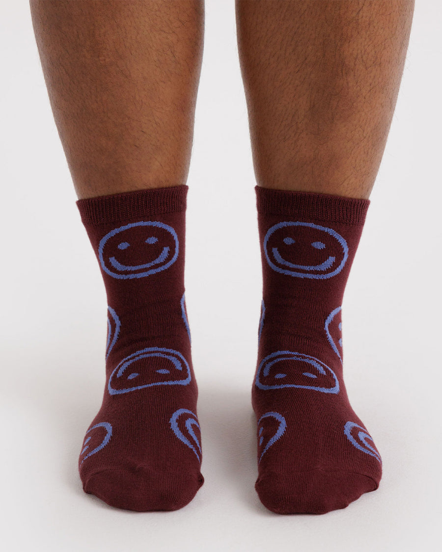 model wearing mahogany crew socks with lilac smiley faces