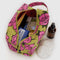 mustard yellow dopp kit with pink rose print with items inside