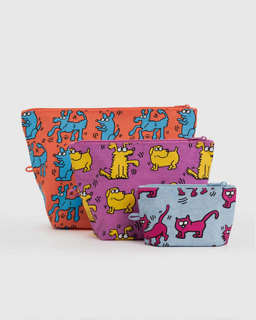 set of three keith haring print pouches: large orange dog, medium purple dogs, and small light blue cat print