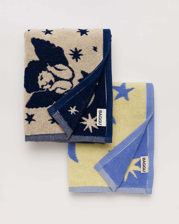 set of two baggu hand towels: cream with cherub and bow print and yellow with moon and star print