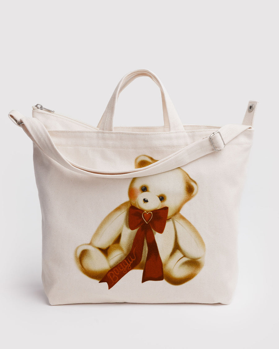 tan horizontal zip bag with teddy bear with a red bow around the neck