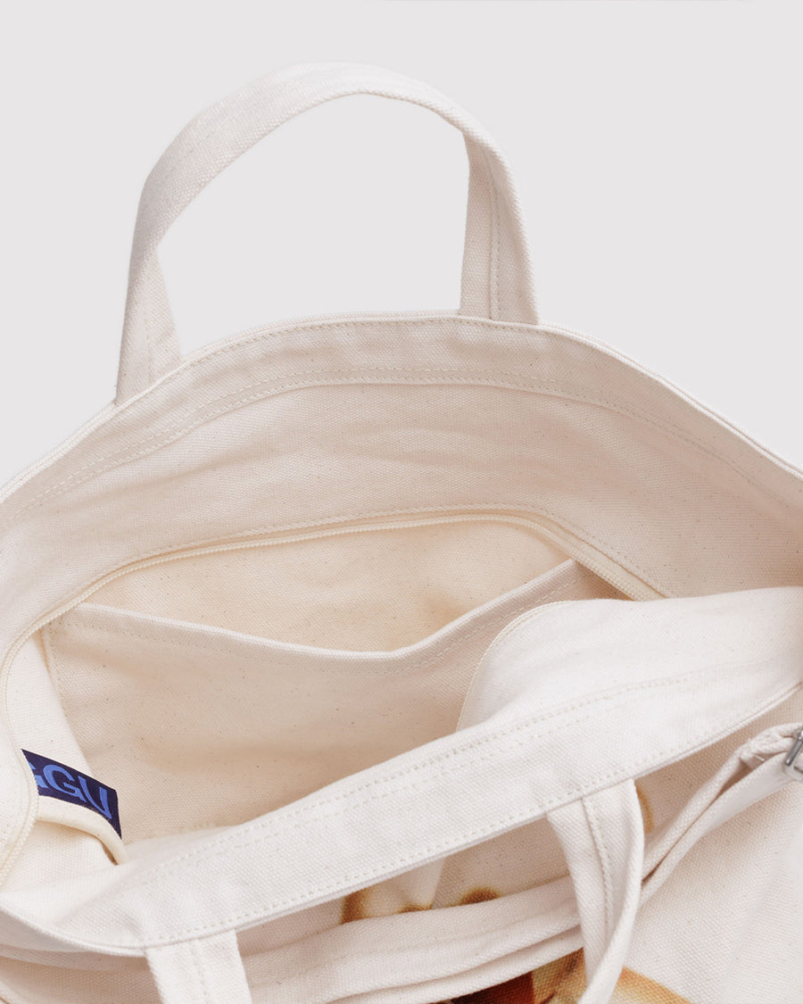 interior of tan horizontal zip bag with teddy bear with a red bow around the neck