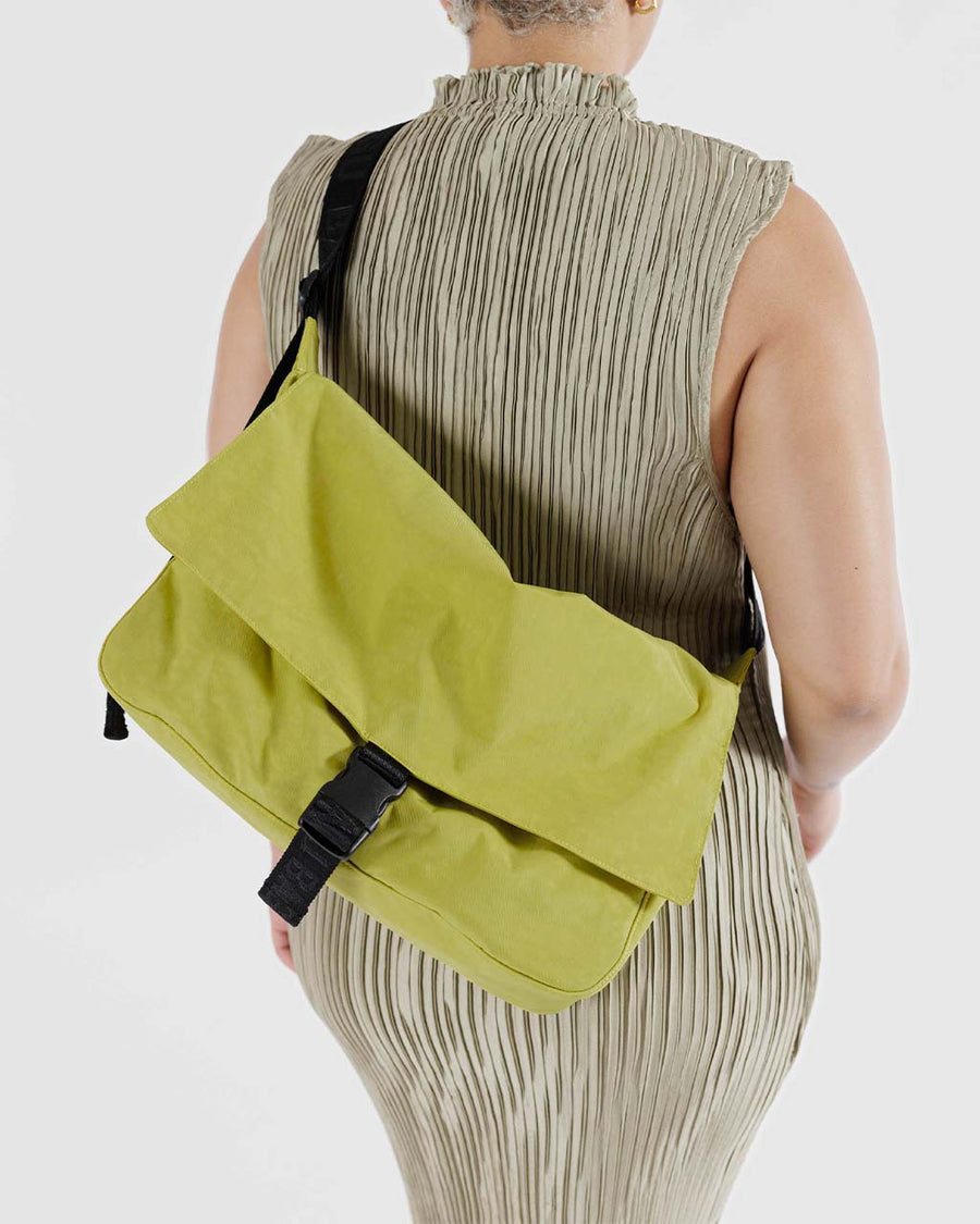 model wearing lemongrass nylon messenger bag with black front buckle