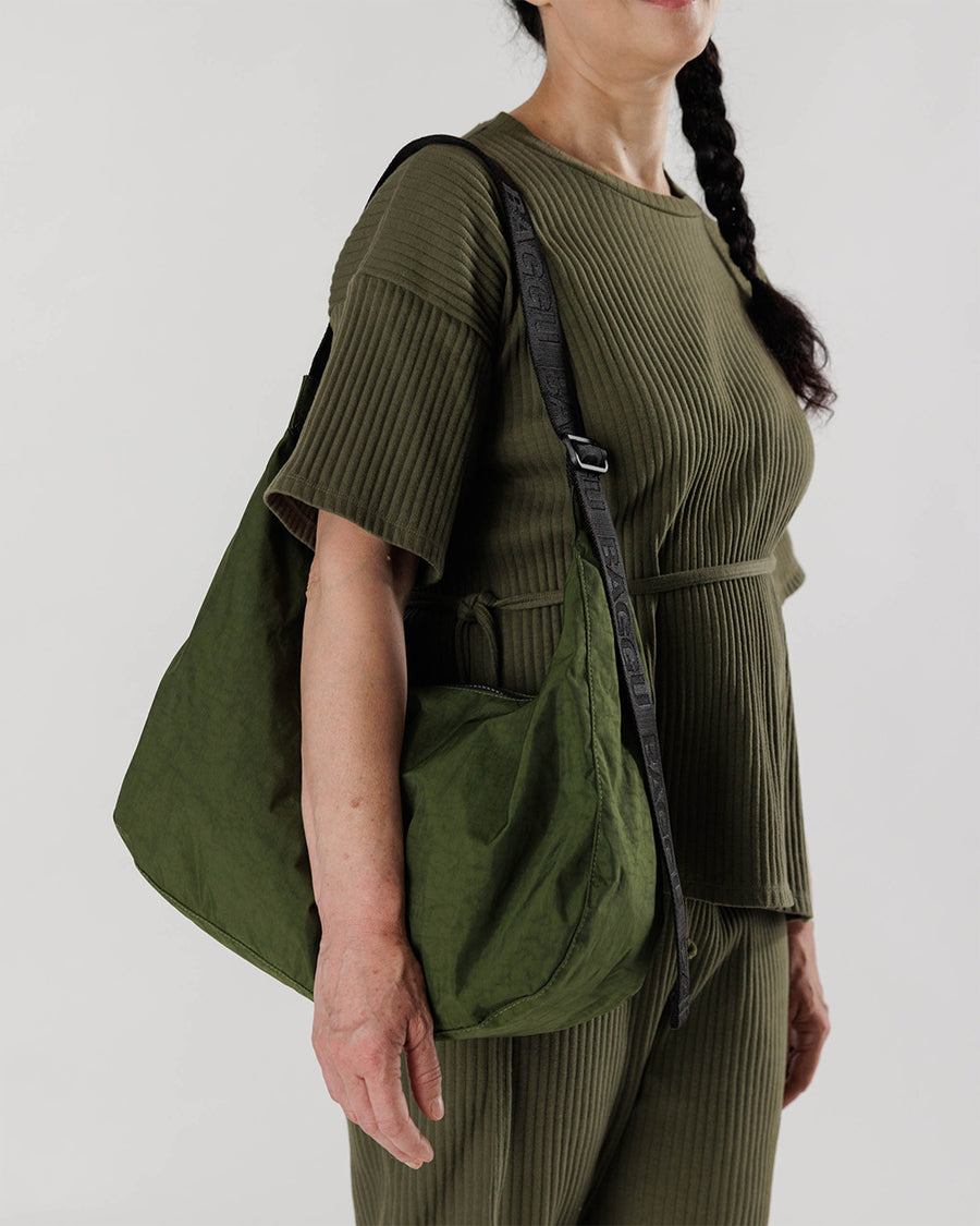 model wearing dark green large nylon crescent bag