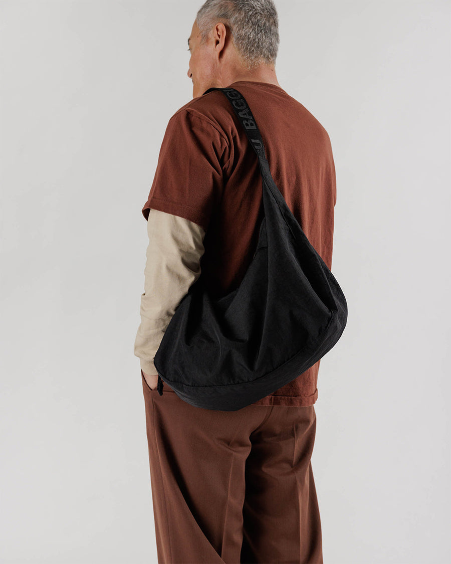 model wearing black large nylon crescent bag
