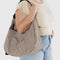 model carrying two tone brown vertical stripe large crescent bag