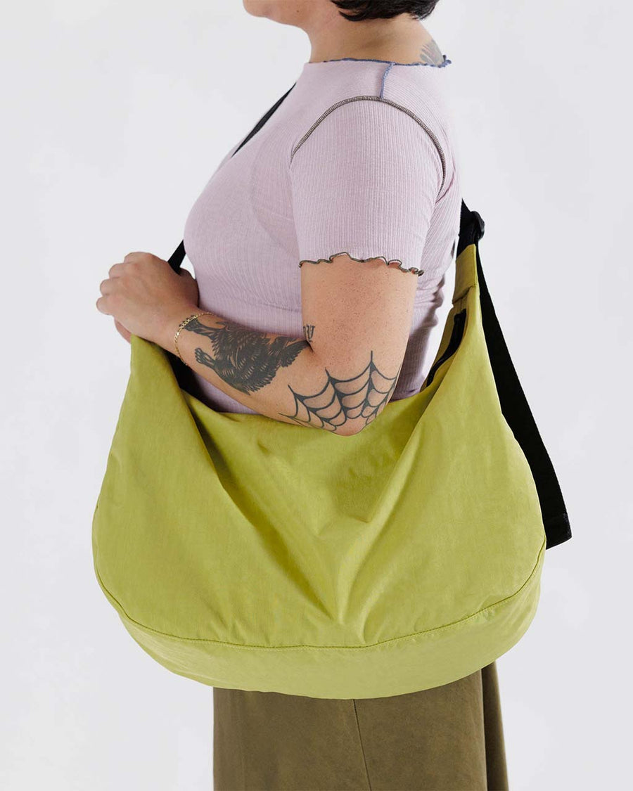 model wearing lime green large crescent baggu bag