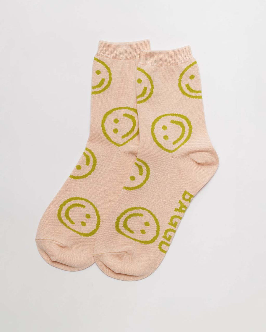 light pink crew socks with yellow/green smiley face print