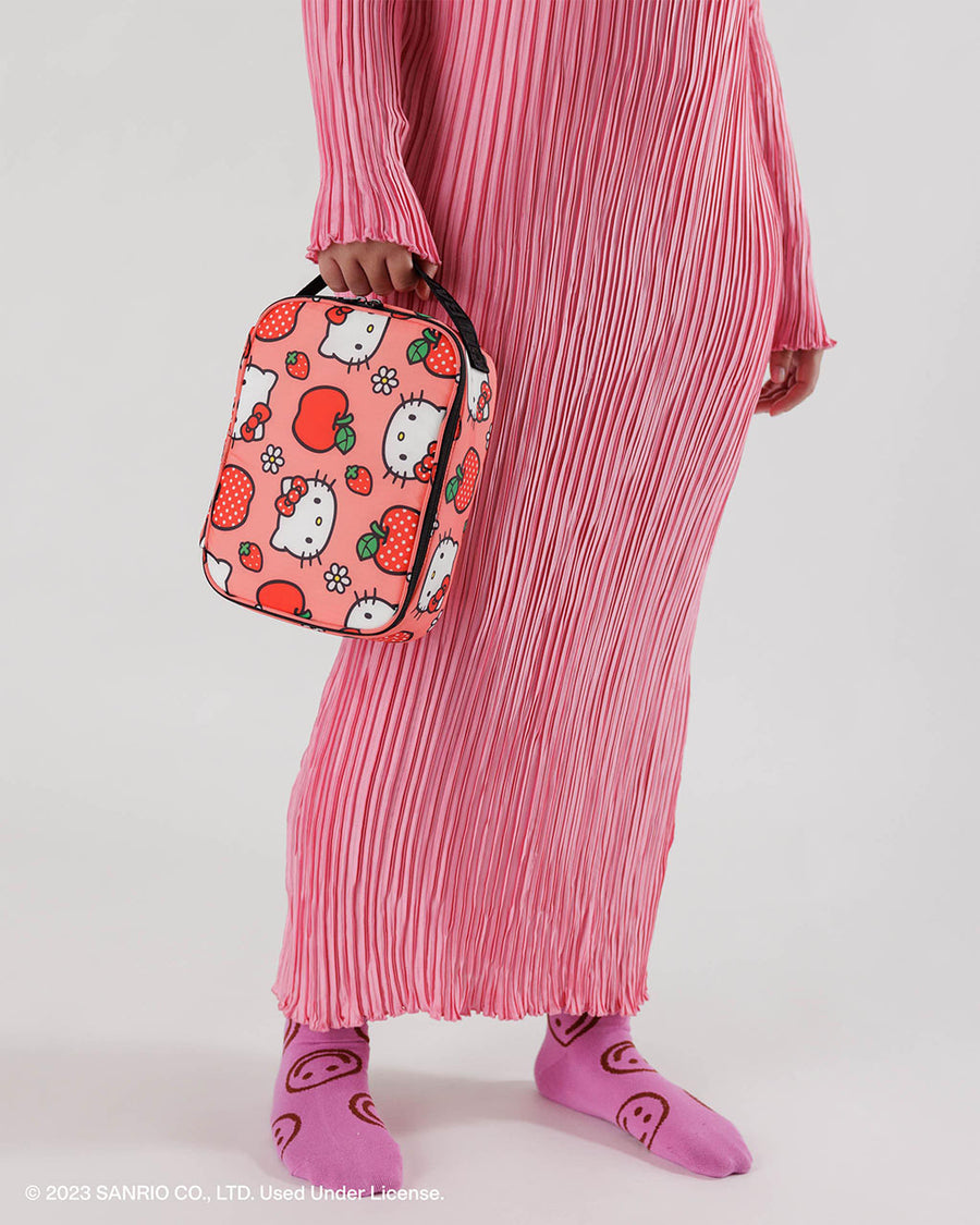 model holding pink baggu lunch box with hello kitty and apple print